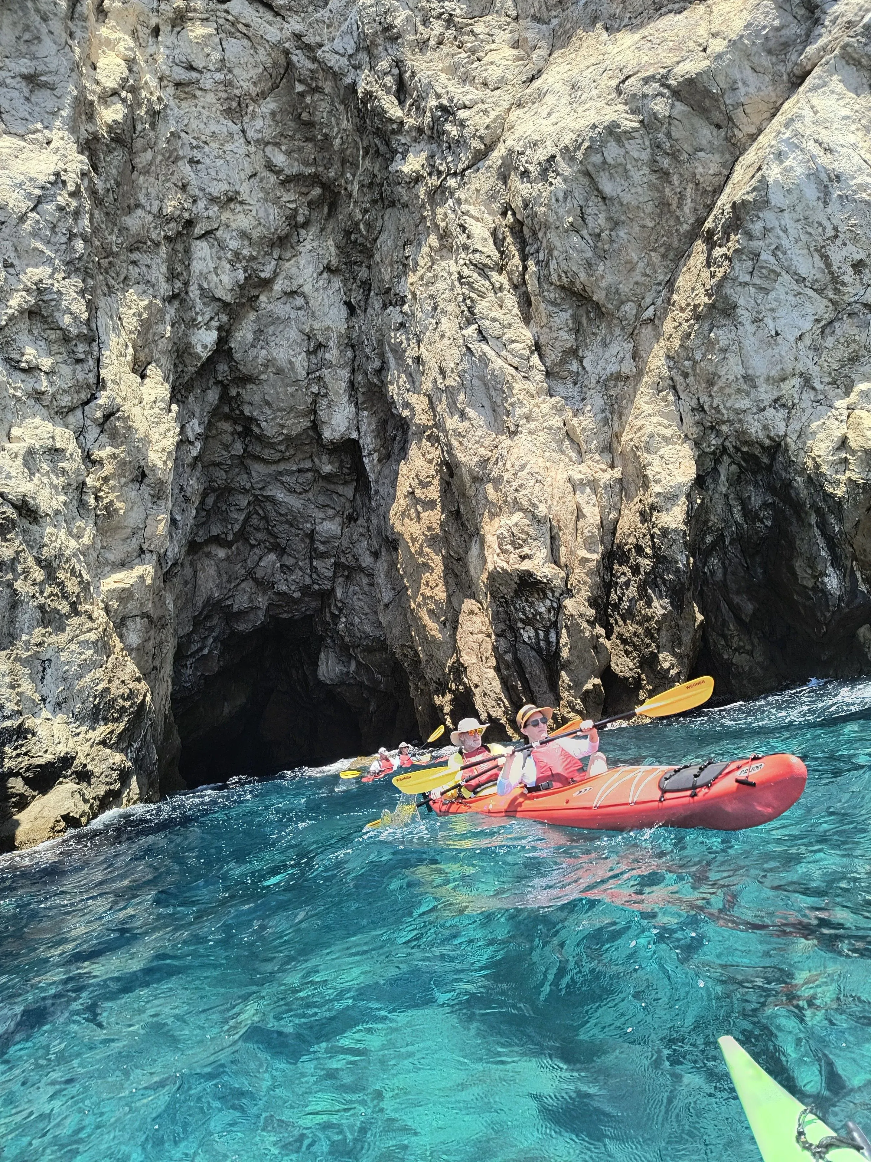 Kayakers paddling through a sea cave